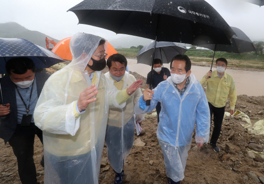 정세균 국무총리(오른쪽 두번째)가 집중호우 피해·복구 현장 점검으로 8일 오전 충남 아산 온양천 일대를 찾아 양승조 충남도지사로부터 현황을 보고받고 있다. <연합뉴스>